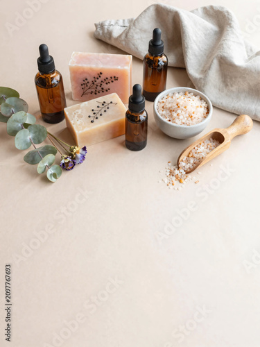 Premium Flat Lay of Natural Herbal Skincare Products with Botanical Soaps, Amber Serum Bottles, Bath Salts, and Fresh Greenery on Soft Pastel Background for Clean Beauty and Wellness Branding