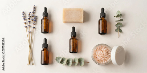Premium Flat Lay of Natural Herbal Skincare Products with Botanical Soaps, Amber Serum Bottles, Bath Salts, and Fresh Greenery on Soft Pastel Background for Clean Beauty and Wellness Branding