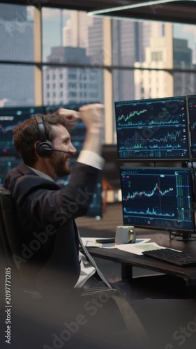 Vertical Screen. Portrait of Stockbroker Wearing Headset Celebrates Winning Trade at Desk, Analyzing Stock Market Data and Financial Charts, Reacting Joyfully to Successful Capital Growth Investment.