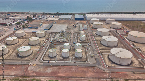 Aerial view of oil storage tanks and industrial infrastructure by sea