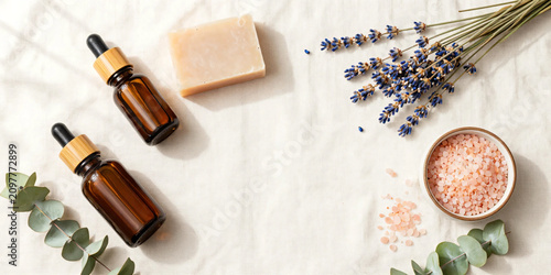 Premium Flat Lay of Natural Herbal Skincare Products with Botanical Soaps, Amber Serum Bottles, Bath Salts, and Fresh Greenery on Soft Pastel Background for Clean Beauty and Wellness Branding