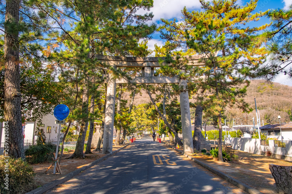 Naklejka premium 岡山県岡山市 青空と松の緑に映える吉備津神社、二の鳥居