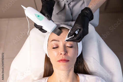 Foto Young woman undergoing hardware cosmetic treatment for facial care in aesthetic