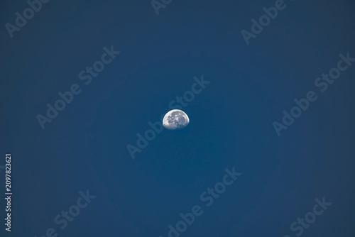 Quadro su tela Detailed gibbous moon in clear blue evening sky.