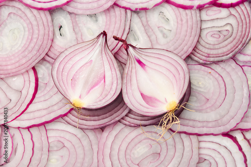 Фотография Red onion rings sliced texture background, Group of chopped onion top view