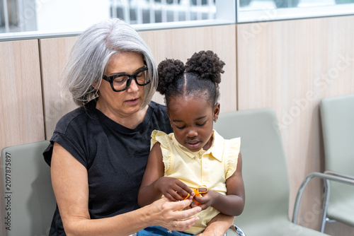 Foto Grandmother comforting grandchild in medical waiting room