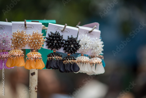 Canvas Print Colorful fashion earrings displayed on a retail market stand with selective focus and blurred background, showcasing affordable costume jewelry for shoppers