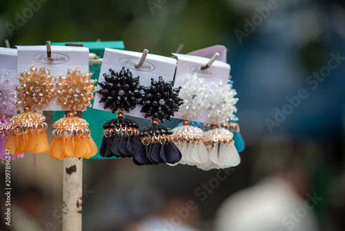 Canvas Print Colorful fashion earrings displayed on a retail market stand with selective focus and blurred background, showcasing affordable costume jewelry for shoppers