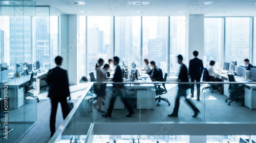 Blurred motion of business people walking in a modern office with large windows and city skyline view