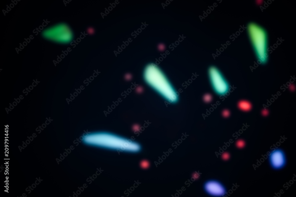 Fototapeta premium Defocussed colorful lights creating beautiful abstract lighting effect on dark background