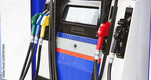 Foto A fuel dispenser with green blue yellow and red nozzles at a gas station