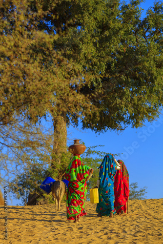 Fotografie women returning towards home after fetching water from well