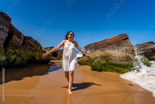 Fotografie Beautiful middle-aged woman enjoying walk on beach on sunny summer day