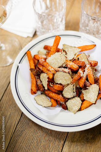 Sweet Potato Fries with Truffle Slices on White Plate
Crispy Vegetable Fries Served with Gourmet Topping
Restaurant Appetizer with Fries and Shaved Truffle