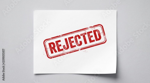 Red Stamp of Rejection: A stark image of a piece of paper with a bold red REJECTED stamp imprinted diagonally, signifying denial or disapproval.