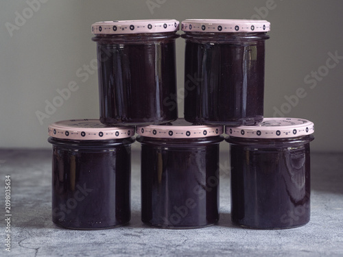 stack of jars of homemade blackberry jam in a pantry
