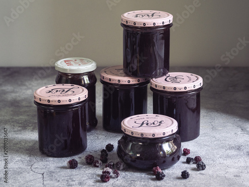 Stack of jars of homemade blackberry jam with the text 