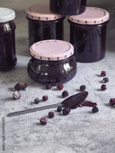 spoonful of homemade blackberry jam accompanied by fresh blackberries