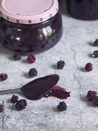 spoonful of homemade blackberry jam accompanied by fresh blackberries