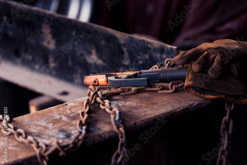 Vászonkép Hands at work with a welder and old, rusty tools