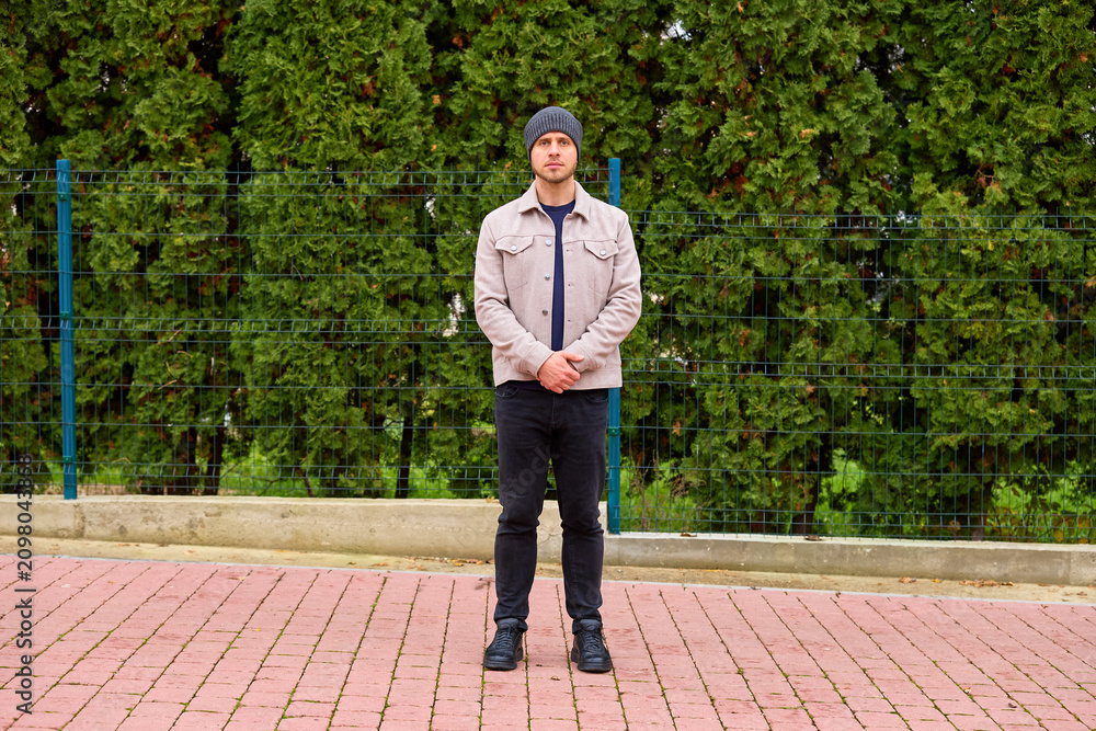 Fototapeta premium Young man stands calmly on a brick path