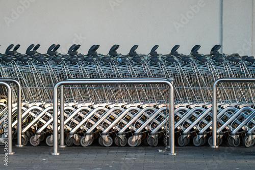 Rows of Shopping Carts Parked Outside Supermarket Entrance Ready for Customers Daily Use and Service
