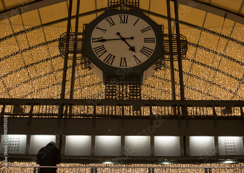 Train station clock with roman numerals, sparkling lights