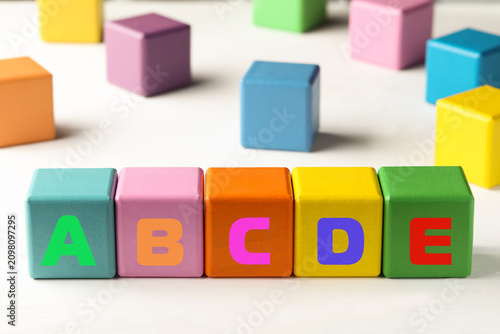Fotografía Learning alphabet. Wooden cubes with letters on white table