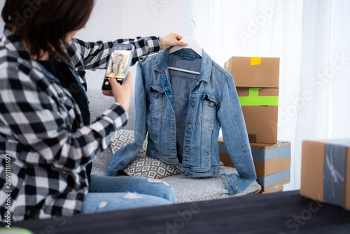 Obraz na płótnie Young Woman Takes Photos Of A Pre-Owned Jeans Jacket For Online Selling And Hold