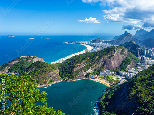 Stunning aerial landscape of Praia Vermelha and the famous Copacabana beach in Rio de Janeiro, Brazil. Blue ocean, lush green mountains, and city skyline.