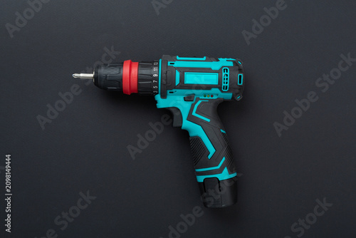 Cordless electric screwdriver on color background, top view