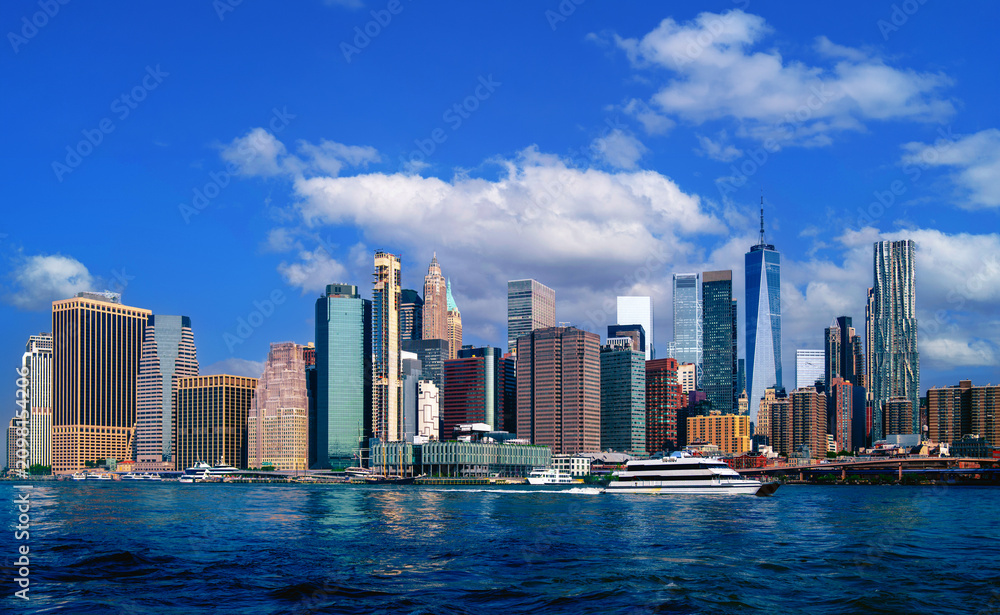 Obraz premium New York City Manhattan skyline, white cloudscape in the blue sky, and East River in New York in the United States of America