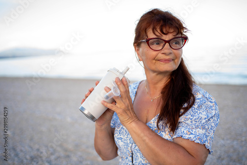 Bild auf Leinwand Senior woman relaxing on the beach at sunset