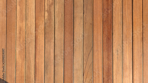 This image shows a wooden deck constructed from narrow, vertical planks with visible natural grain textures