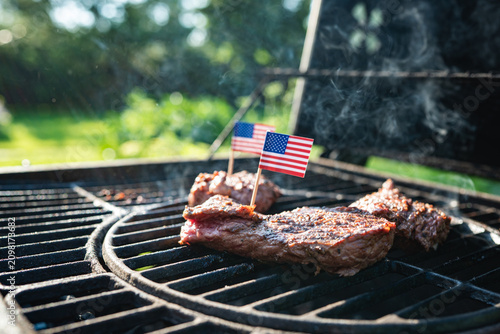 American barbecue steaks on grill with USA flags for Independence Day