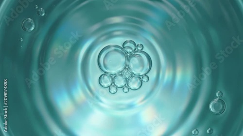 Transparent bubbles floating and rippling in teal liquid for beauty and cosmetic content