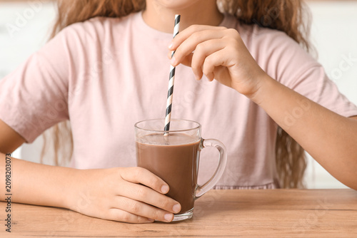 Cute girl with glass cup of...