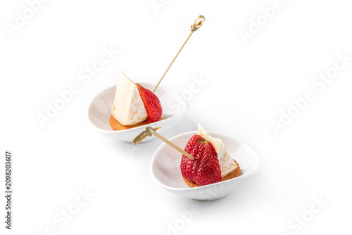 Appetizer with cheese, strawberries, cookies, isolated on white background. Catering food, canape and snacks, close up