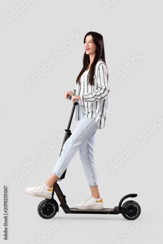 Young woman riding electric...