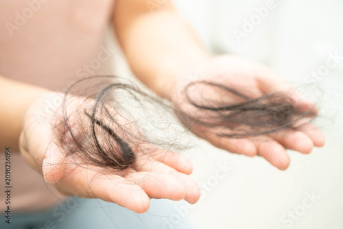 Canvas Print Asian woman have problem with long hair loss attach in her hand.