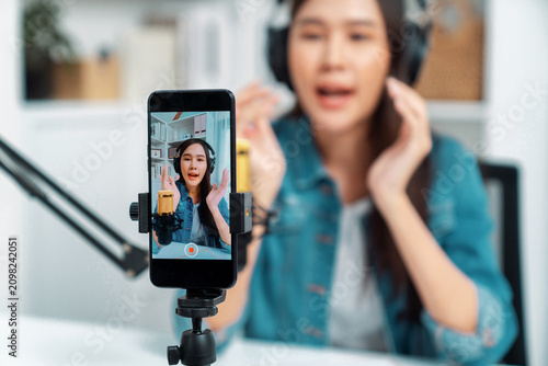 Bild auf Leinwand Selective focus phone in host channel of young beautiful Asian in creative broadcaster talking online explaining to promote marketing or consultant in daily life with listener at studio