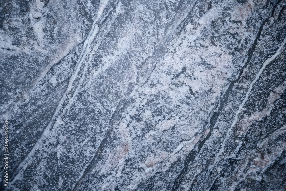Naklejka premium Blue-grey granite surface with diagonal crystalline mineral veins background texture