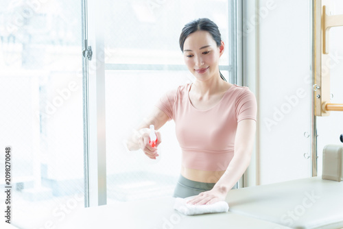 ピラティスマシンをクリーニングする女性