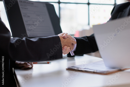 Quadro su tela Business people shaking hands in an office, finalizing an agreement and partners