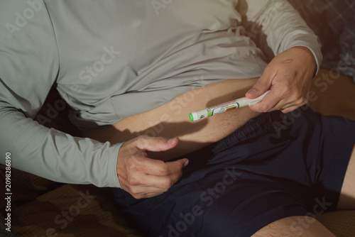 Tableau sur toile An elderly man is injecting himself with a drug into his abdomen.