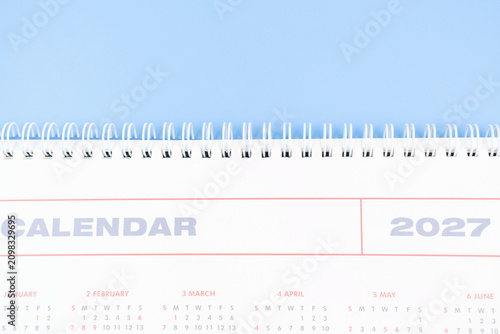 Calendar for 2027 on blue background close-up top view.
