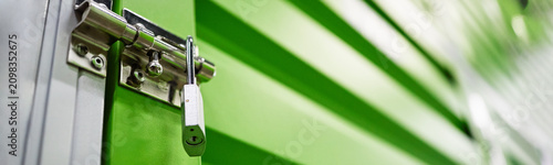 Fotografie Close up of storage unit door locking with padlock, securing individual belongings in self storage facility