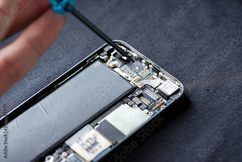 The smartphone was damages and need to repair which tools smartphone that stand isolated on white background by hands of repairman.	