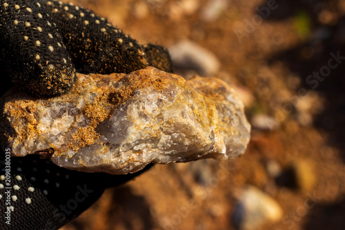 Принти на полотні Raw granite pegmatite specimen held in a gloved hand, detailed crystalline textu