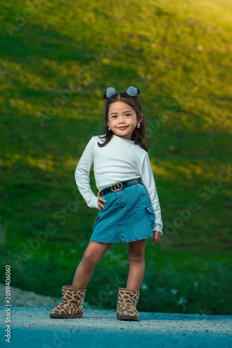 Foto Cute little in stylish clothes posing outdoors on a sunny day